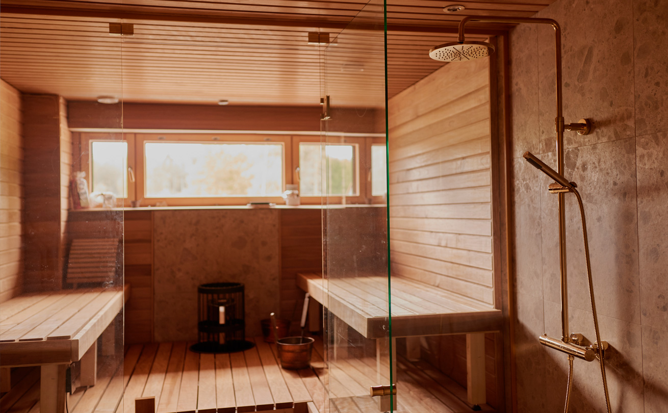 Valoisa vaalean puun värinen sauna.